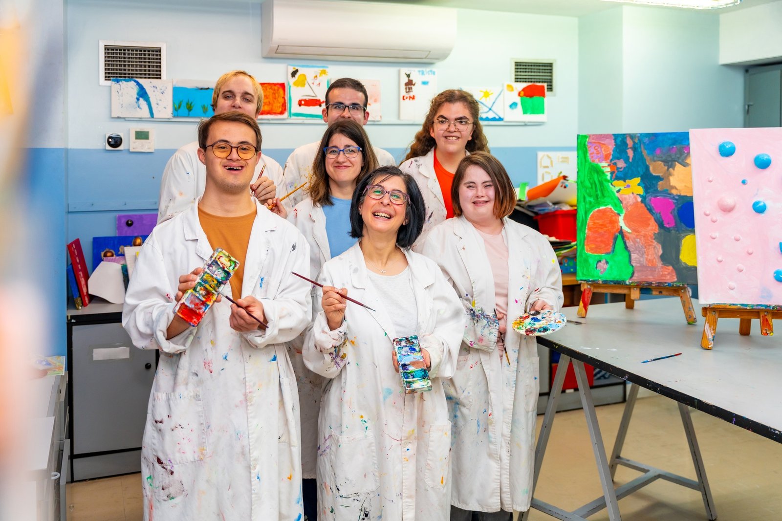 Class painting group with white coats with mental disabled people