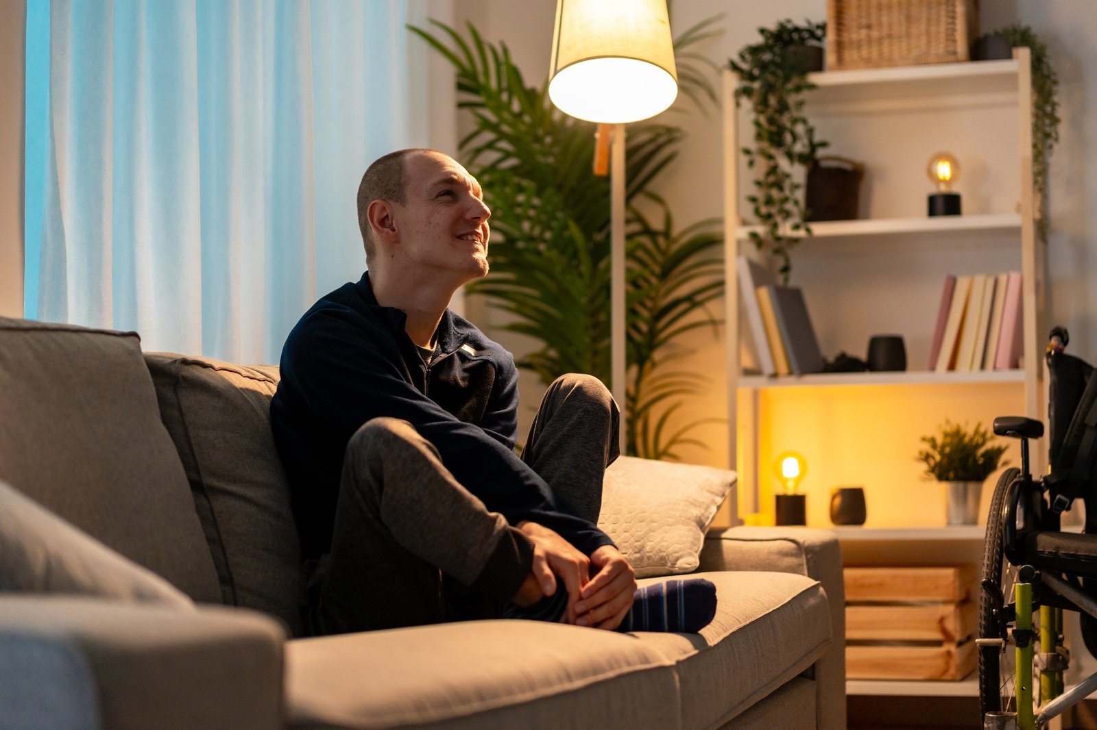 Sad disabled man alone at home looking up in despair